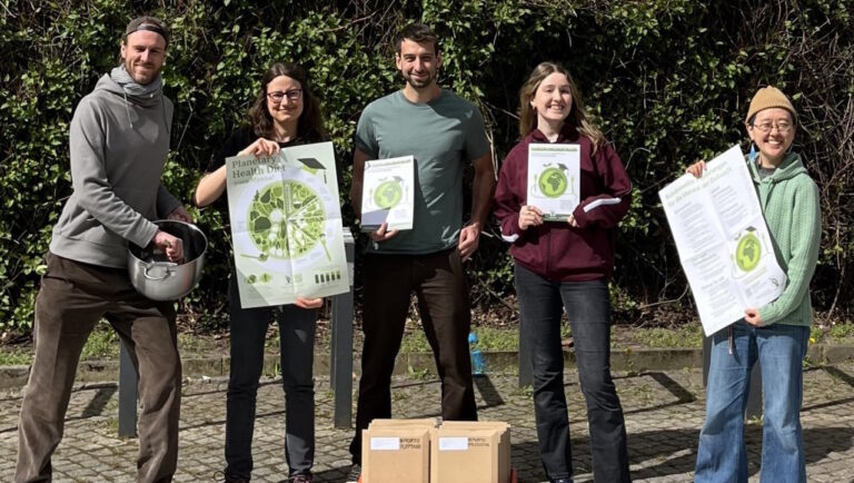Fünf Studierende der Initiative Mensarevolution halten Plakate.