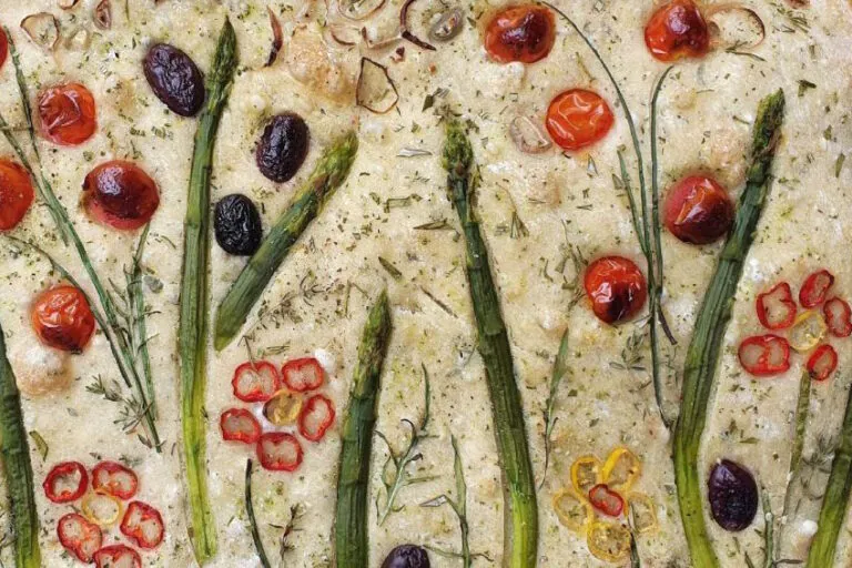 Ein Focaccia-Brot mit Gemüse in Form von Pflanzen und Blumen.