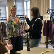 vier Frauen probieren bei einer Kleidertauschparty neue Styles aus